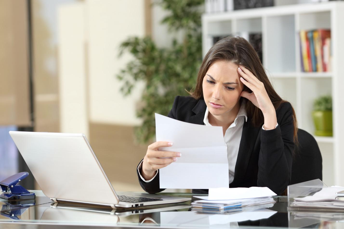 A person looking at a piece of paper
Description automatically generated